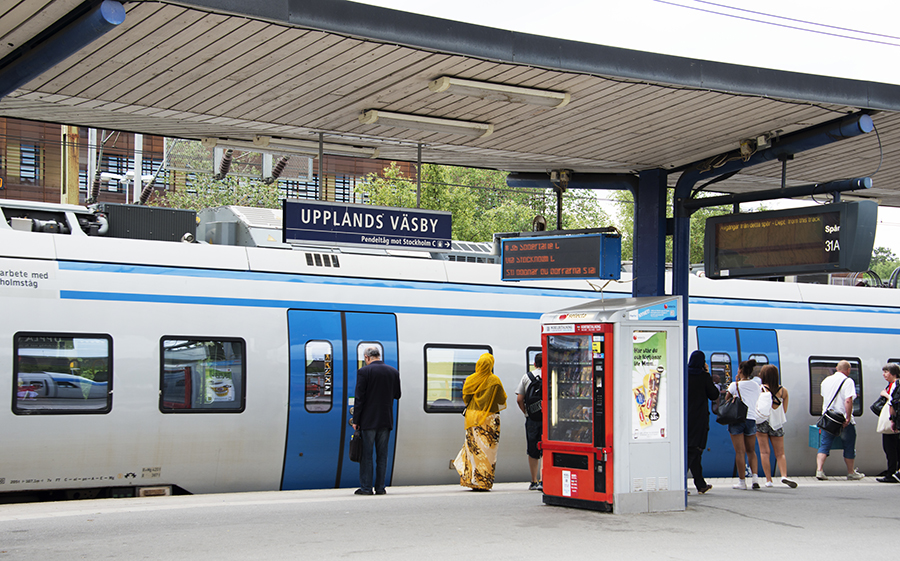 Pendlare väntar på att gå på pendeltåget vid Upplands Väsby station. 
