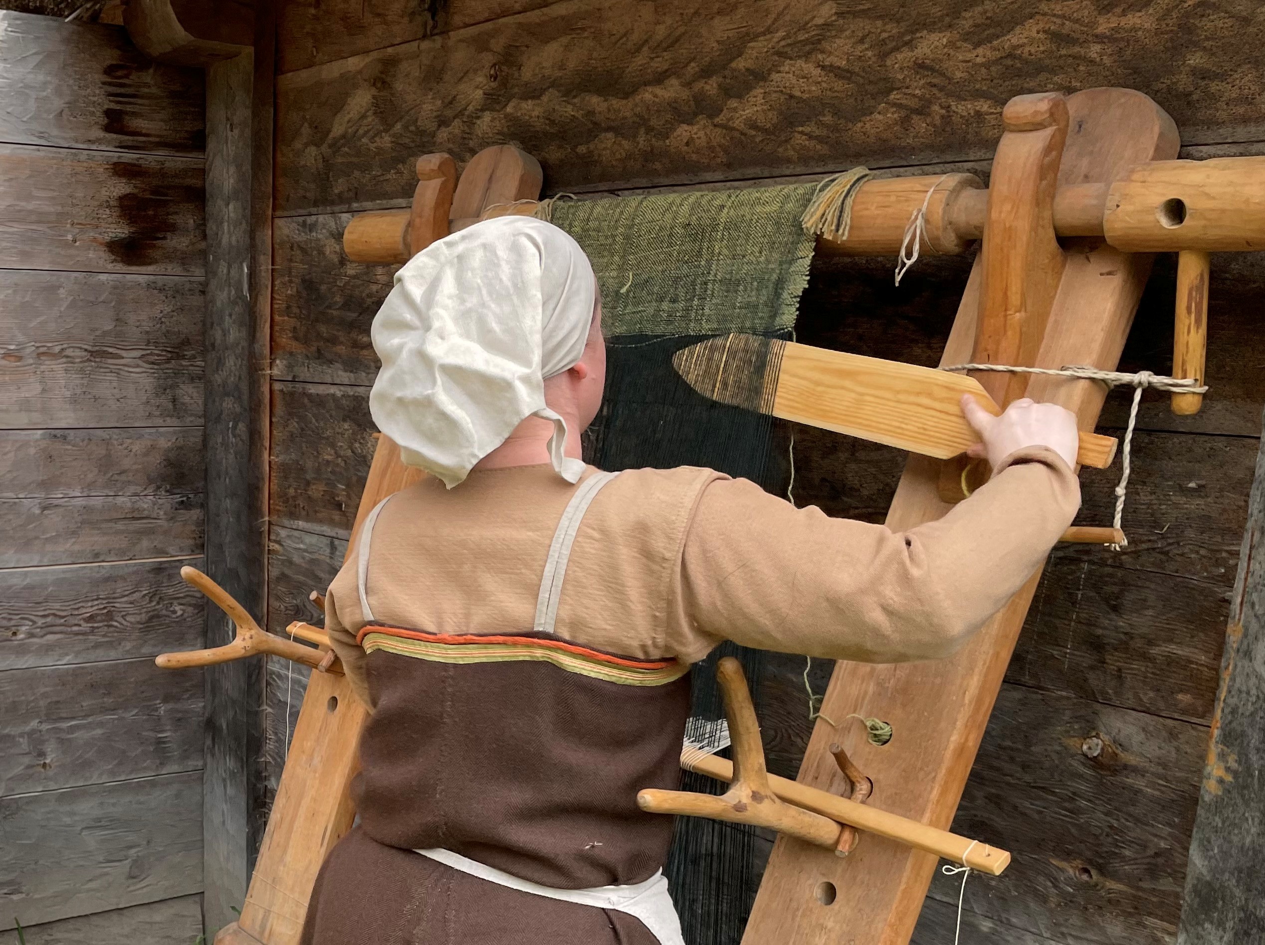 En person med vikingakläder som arbetar.