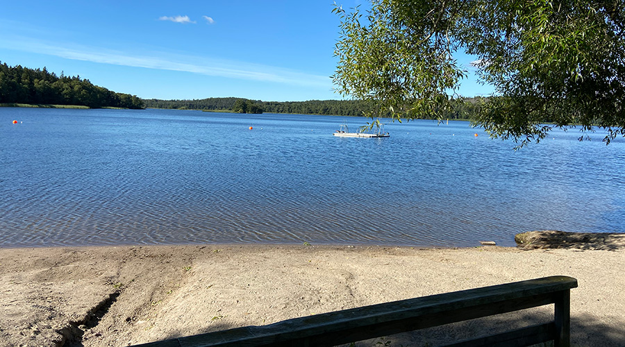 Bild på sandstranden och utsikt över vattnet på Kairobadet. Ute på vattnet ser man bryggan som flyter.  