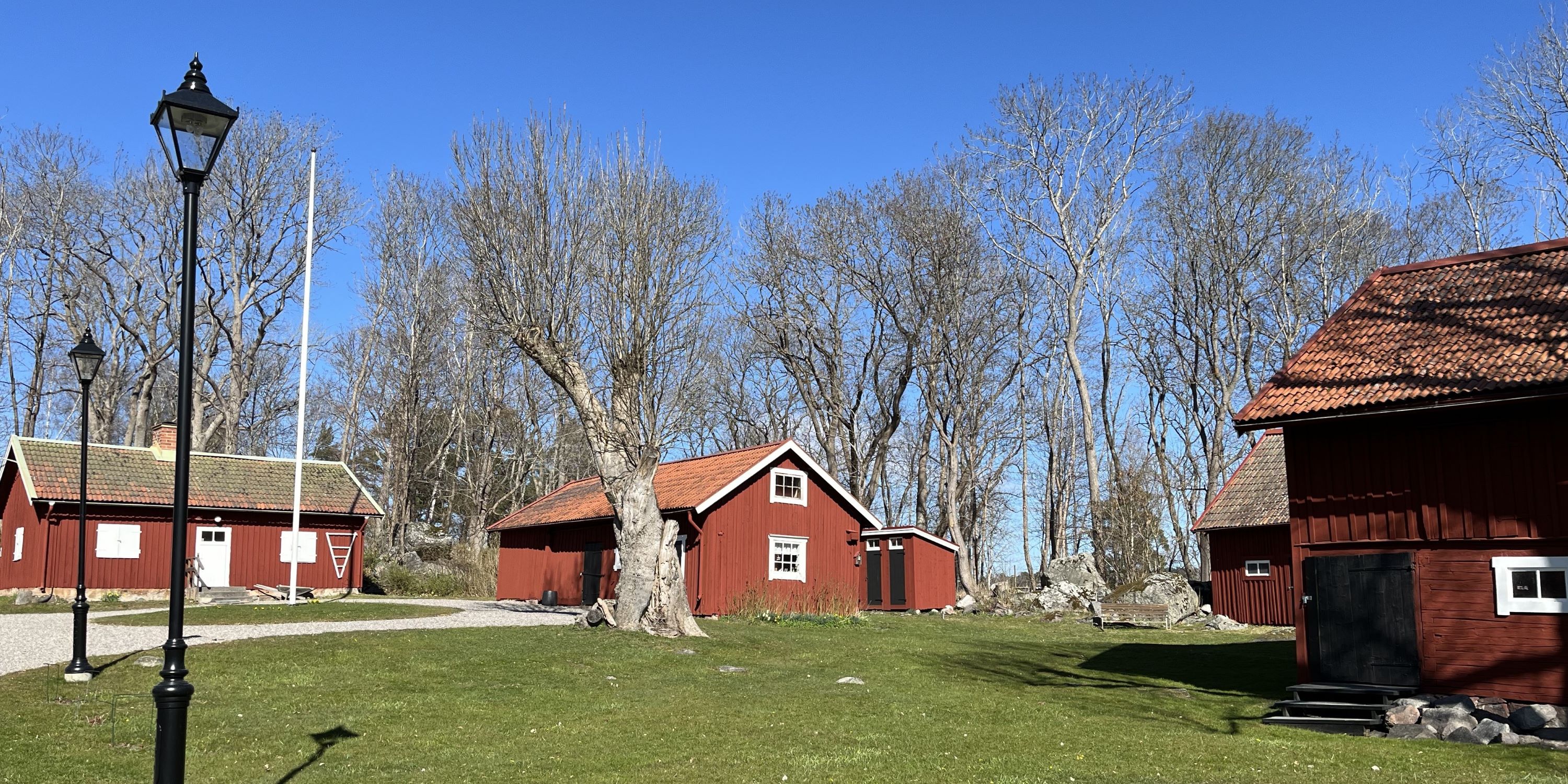 Röda hus, en flaggstång och en gräsmatta.