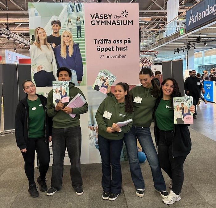 Fem ambassadörer. De håller i programblad och ler.