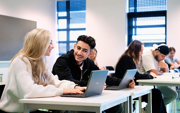 En kille och en tjej sitter i ett klassrum.
