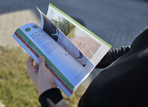 Händer som bläddrar i idékatalogen.