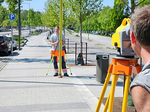 Mattias Arvidsson (närmast) och Peter Isaksson från kommunens geodataenhet jobbar med mätningar längs Mälarvägen.