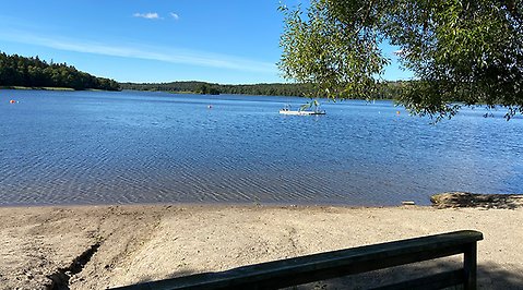 Bild på sandstranden och utsikt över vattnet på Kairobadet. Ute på vattnet ser man bryggan som flyter.  