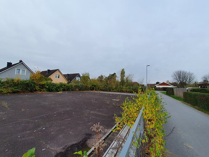 Fresta asfaltsyta. En stor asfaltsyta med hus runtomkring. Det finns växter i närheten av planen.