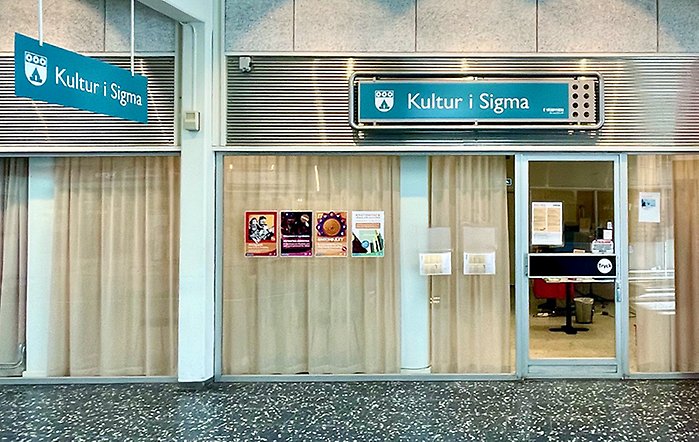 Interiör från Sigma Centrum med ingången till lokalen och blå skyltar med Kultur i Sigmas logotyp på.