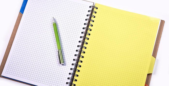 Uppslagen anteckningsbok i gult och vitt ned en penna liggande på.