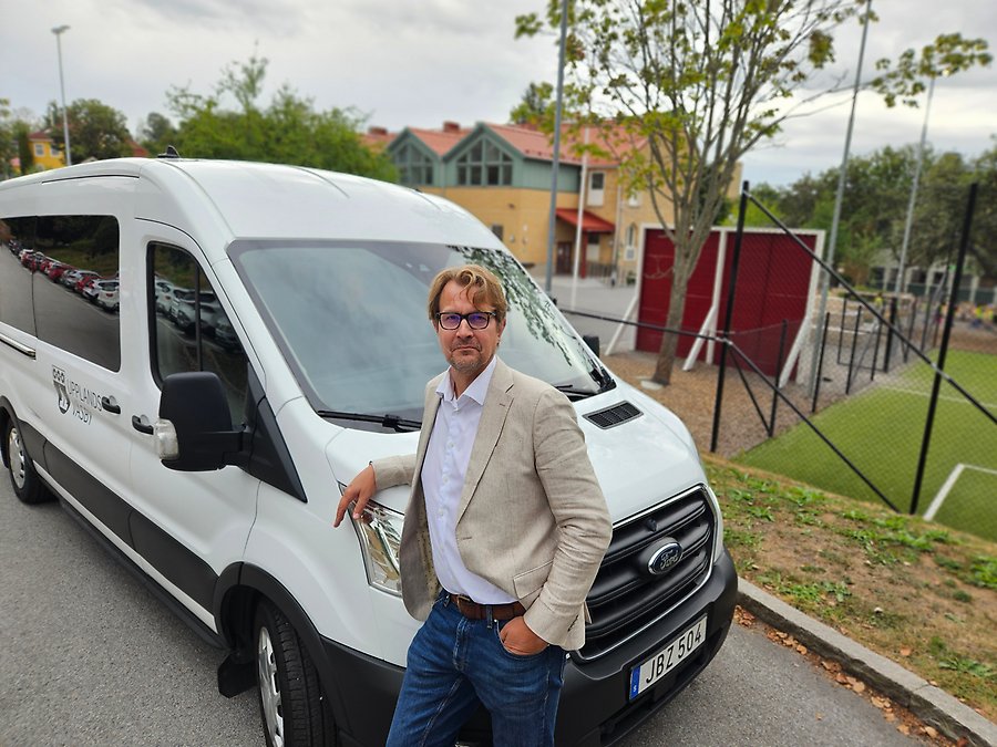 En man står framför en av bilarna som kommer att användas för persontransporter.
