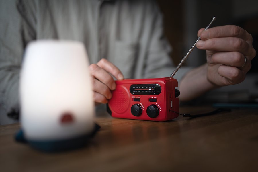 Person ställer in röd vevradio.