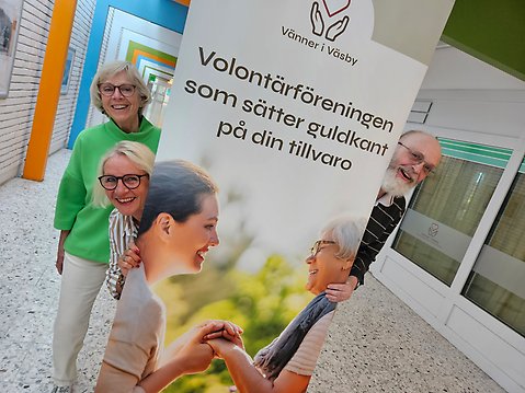 Tre personer står på varsin sida om en skylt som handlar om Vänner i Väsby.