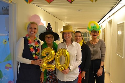 Fem kvinnor med roliga hattar och jirlanger runt halsen