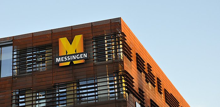 Bild av Messingens utsida, med stor skylt av ett M och blå himmel