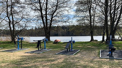 Ett utgym med träd och en upp och nedvänd båt i bakgrunden. 